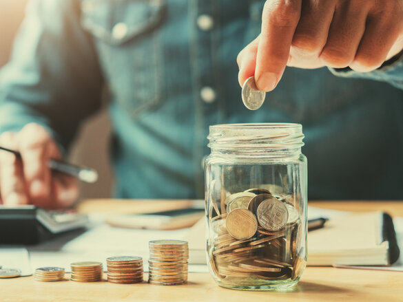 businessman holding coins putting in glass. concept saving money for finance accounting